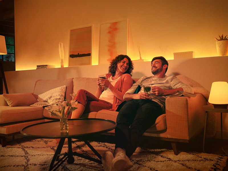 Paar im Wohnzimmer Philips Hue Hintergrundbeleuchtung