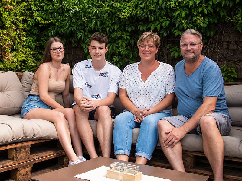 Joline Sill, Jerome Sill, Christiane Sill und Ronald Sill sitzen nebeneinander auf einer Couch auf der Terasse