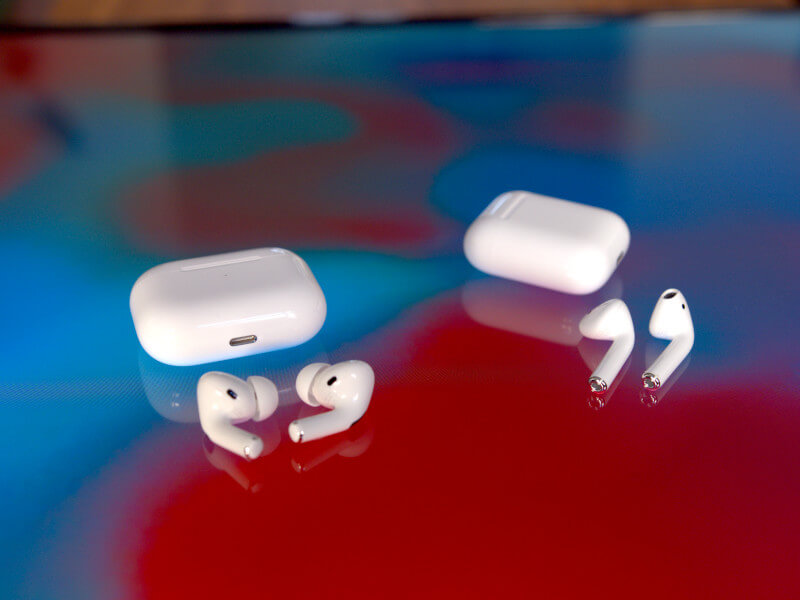 Apple AirPods Pro und AirPods samt Ladecases nebeneinander auf einem Tisch