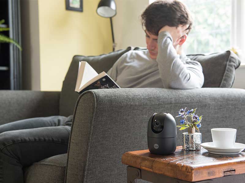 Yale WLAN Innenkamera mit Schwenk- und Neigefunktion in Wohnzimmer Mann mit Buch