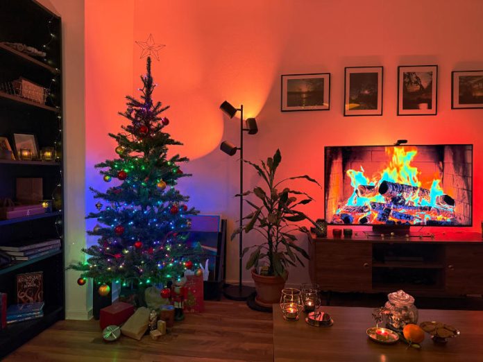 Govee Lichterkette am geschmückten Weihanchtsbaum, Kaminfeuer auf dem Fernseher mit TV-Backlight, Govee Tree Light beleuchtet die Wand und Decke