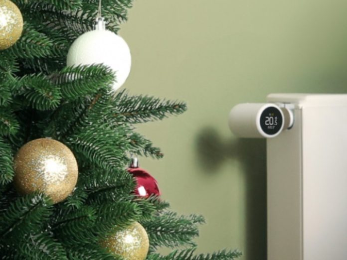 tado° X Thermostat am Heizkörper neben geschmücktem Weihnachtsbaum