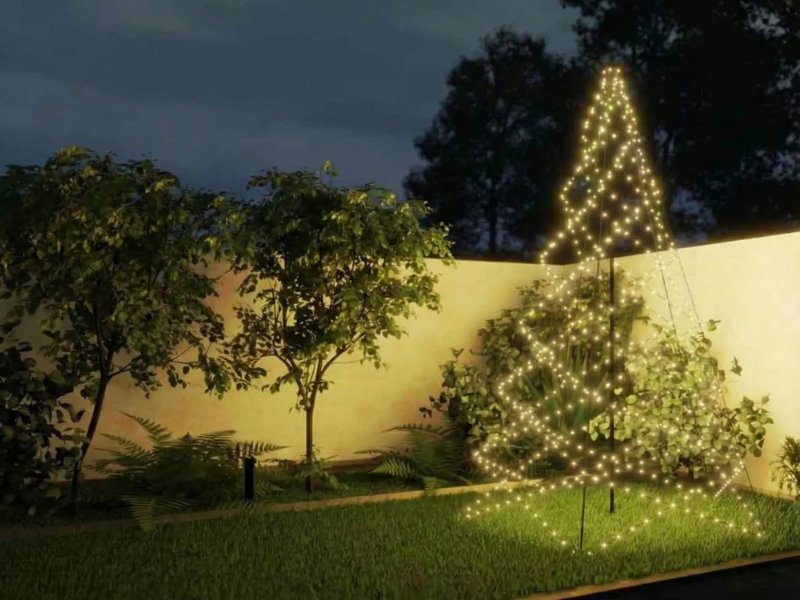 Stimmungsvolles Abendfoto eines Gartens mit warmweißen, kegelförmigen Smart-Weihnachtslichtern auf dunkelgrünem Gras vor einer cremefarbenen Wand.