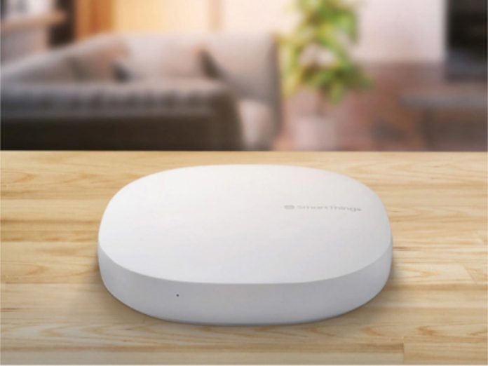 Samsung SmartThings Hub auf einer Holzoberfläche. Dieses Bild ist relevant, falls Nutzer in SmartThings mehrere Benutzer hinzufügen wollen.