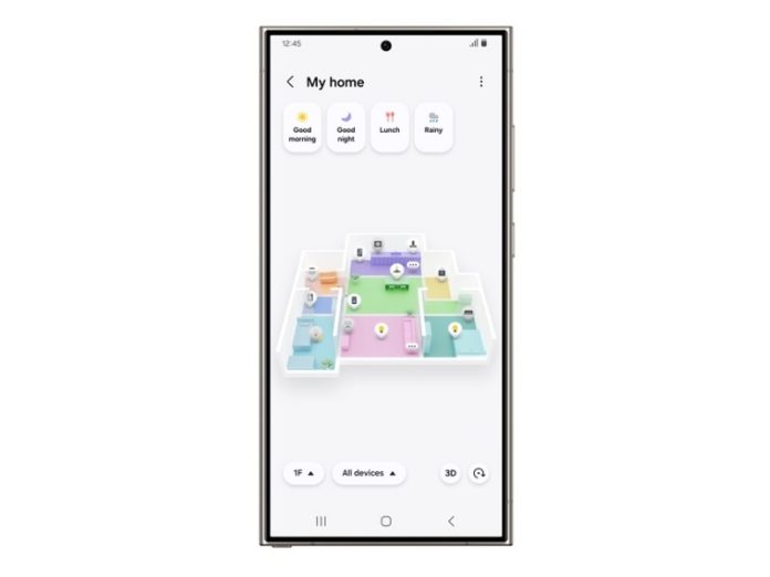Samsung Smartphone mit der Samsung Smarthings App, die eine 3D-Grundrissansicht eines Hauses mit farbigen Räumen (z.B. Pink, Grün, Blau) und Steuerelementen für Smart-Geräte anzeigt.