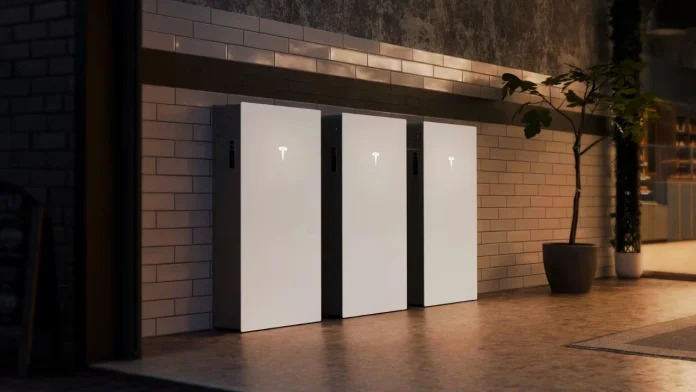 Drei schlichte, weiße Tesla Powerwall 3P-Heimspeicher sind an einer gefliesten Wand in einem modern gestalteten Raum mit Stimmungsbeleuchtung angebracht.