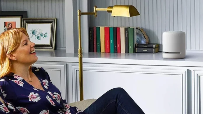 Lachende Frau in stilvollem Interieur mit einem weißen Amazon Echo Smart Speaker.