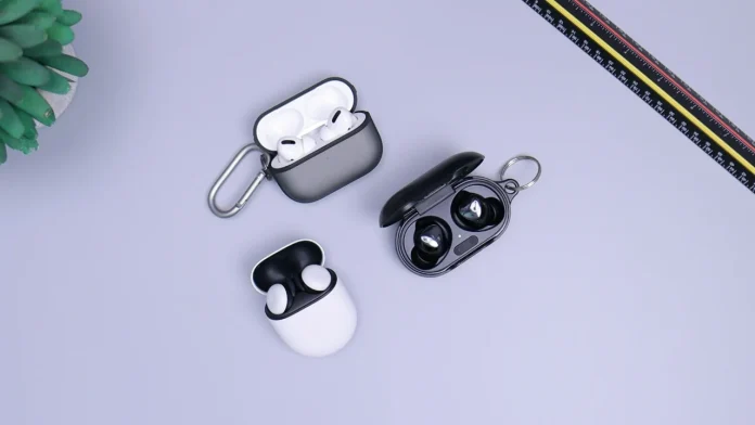 WLAN-Ohrhörer: Drei verschiedene kabellose Earbud-Sets in Ladecases vor grauem Hintergrund.