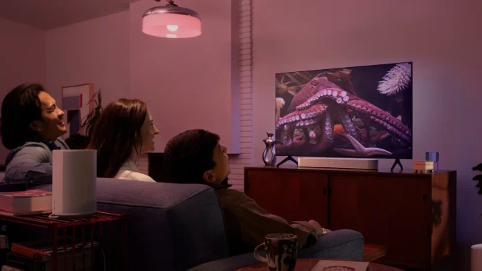 Die Familie genießt einen Film mit stimmungsvoller Hue-Sonos-Beleuchtung und Sound im Wohnzimmer.