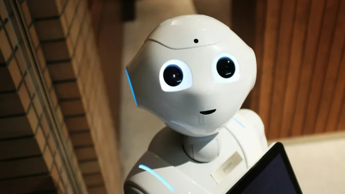 Weißer humanoider Roboter mit großen Augen und einem Tablet zur Interaktion.