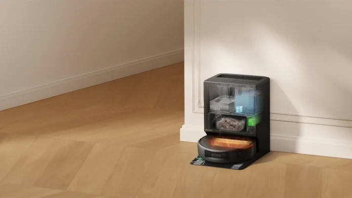 Ein Roomba-Staubsaugerroboter an seiner transparenten, selbstentleerenden Ladestation, die auf einem Holzboden die inneren Behälter zeigt.