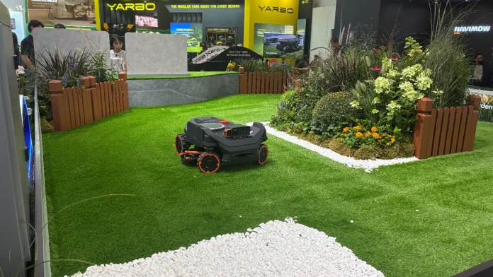 Der Segway Navimow-Mähroboter auf Kunstrasen in einer Gartenausstellung.
