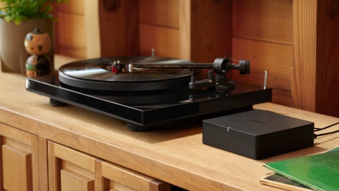 Sonos Port neben einem schwarzen Plattenspieler auf einem hölzernen Sideboard