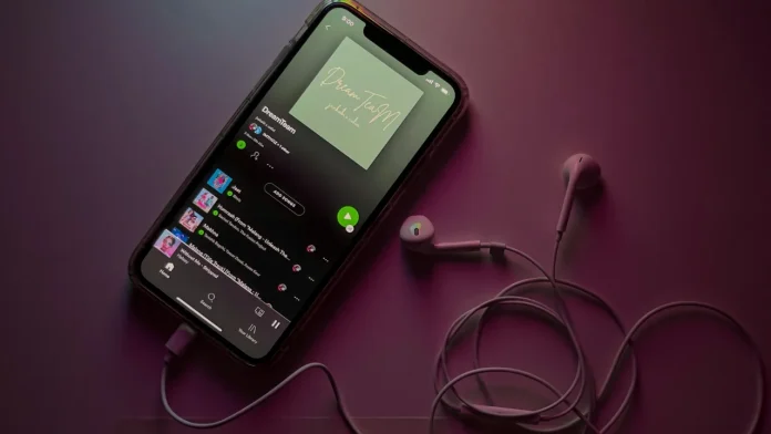 Spotify-Playlist auf einem iPhone mit weißen Kopfhörern und lila Ambientelicht.
