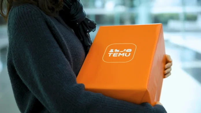 Eine Frau hält ein orangefarbenes Temu-Paket in der Hand.