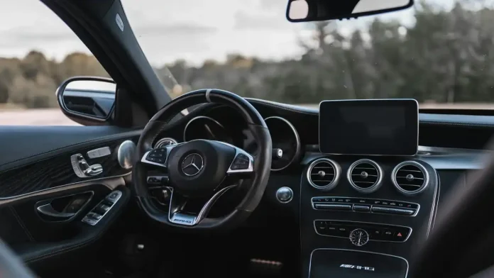 Innenraum eines Mercedes-AMG mit Lenkrad und Infotainment-Display, Sinnbild für den ADAC Sprachsteuerung Test
