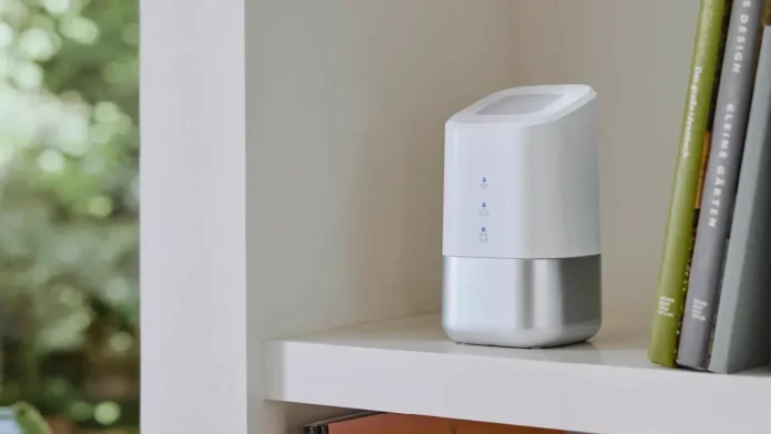 Weiße Homematic IP Smart-Home-Zentrale auf einem Regal neben Büchern in einem vernetzten Zuhause.