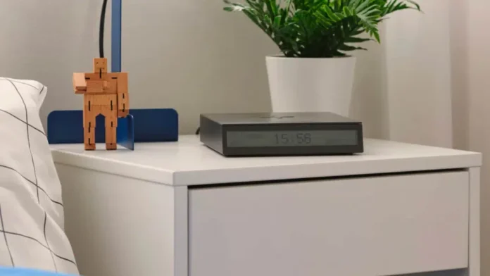 IKEA STENGRÖNSKA Wecker mit Klimamesser auf einem weißen Nachttisch neben einer Pflanze und einer Holzfigur