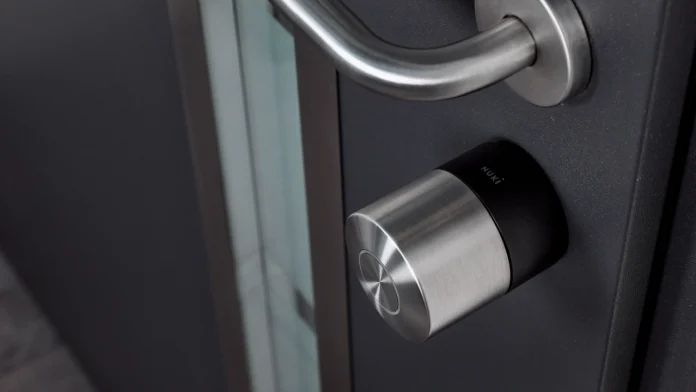 Ein modernes Nuki Smart Lock aus Edelstahl an einer anthrazitgrauen Tür bietet einen klaren Überblick für alle, die verschiedene Nuki-Smart-Lock-Modelle vergleichen wollen.