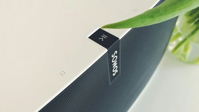 Sonos Lautsprecher mit grüner Pflanze auf einem hellen Tisch