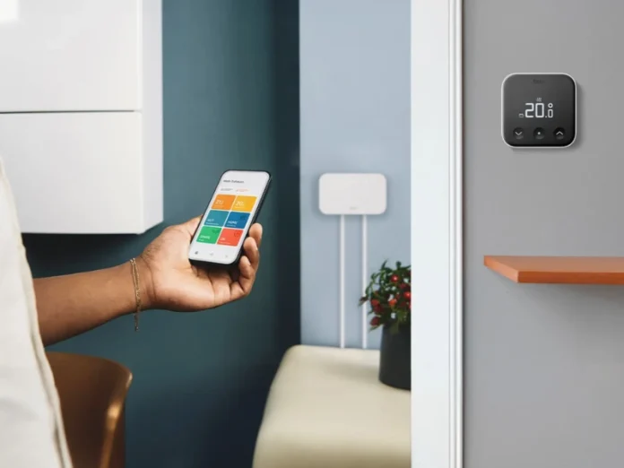 Gastherme smart machen: tado° X Funkempfänger am Heizkessel im Hintergrund, Funk-Temperatursensor und Mann mit App im Vordergrund