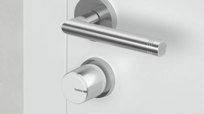 tedee Lock GO 2 Smart Lock an einer weißen Tür neben der Türklinke